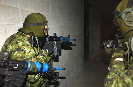 Canadian soldiers clear a building