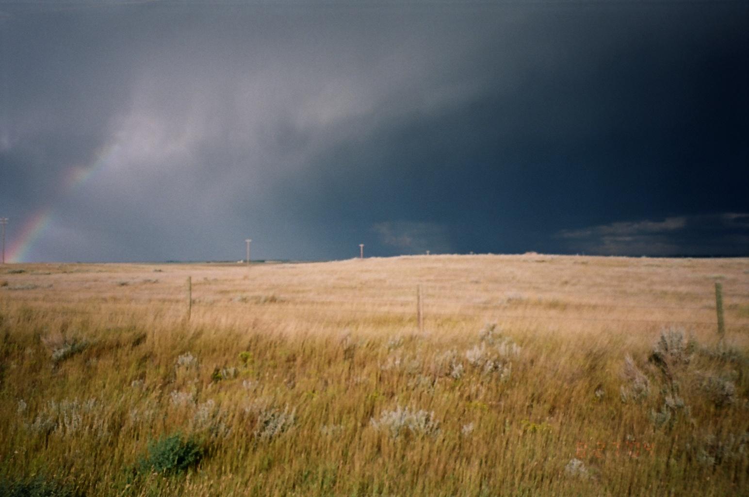 This photograph was taken just outside of Kinbrook Island Provincial Park, near Brooks, Alberta.  The storm cell raging over the farmland was moving fast, but not quite fast enough to block out the rainbow that appeared on the left.

This photo is copyrighted to me.